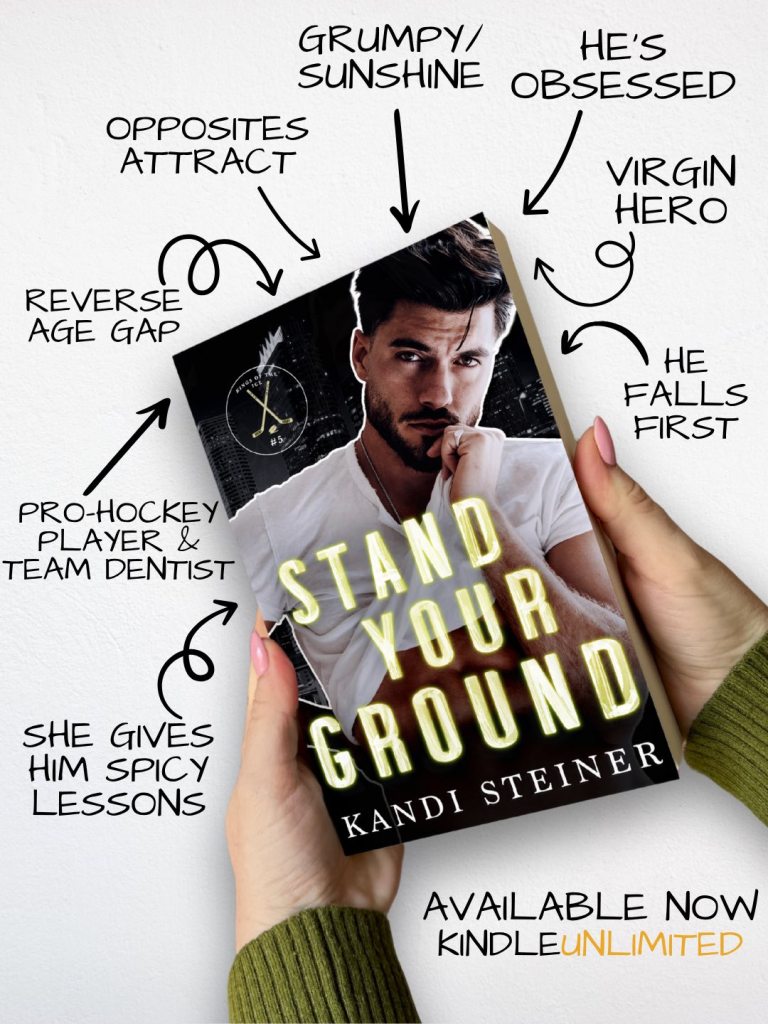A person holding a book titled 'Stand Your Ground' by Kandi Steiner, featuring a male model on the cover. Surrounding text highlights themes like opposites attract, reverse age gap, and grumpy/sunshine dynamic. The book is promoted as available on Kindle Unlimited.